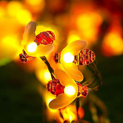 Honey bee string lights illuminating a garden party